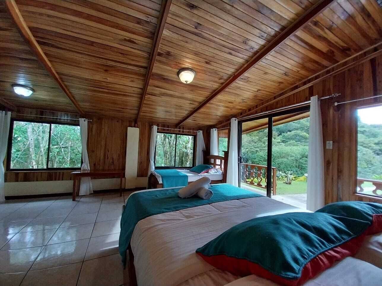 Wooden cabin room with two beds, a balcony and large windows