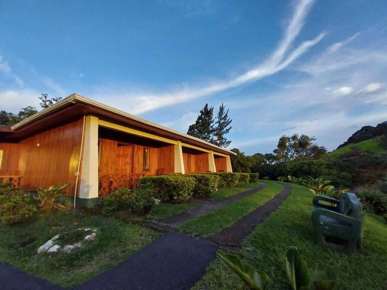 Wooden building with a path leading to it, surrounded by trees