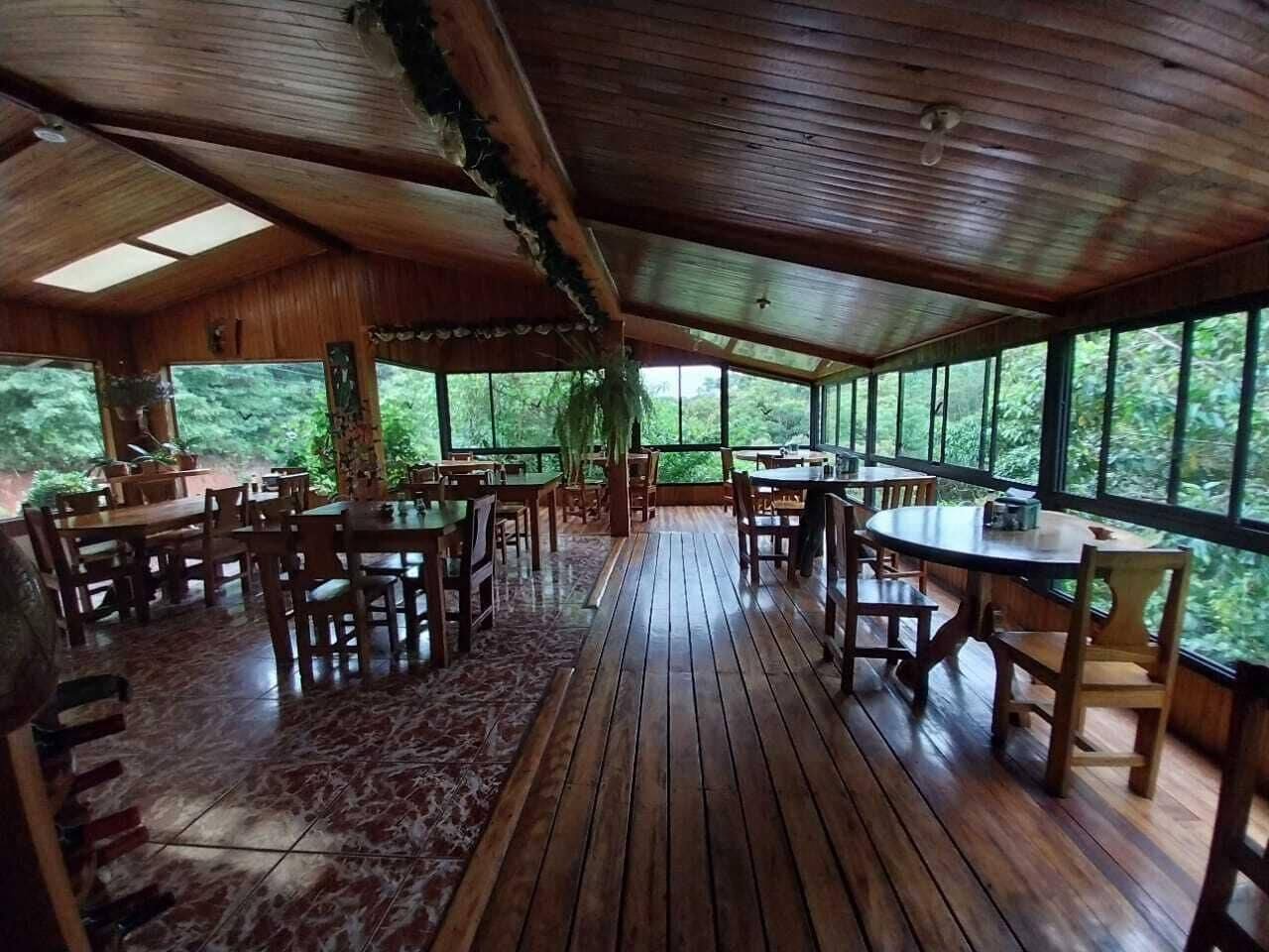 Wooden dining room with tables, chairs and large windows